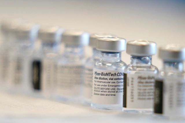 Bottles of the Pfizer-BioNTech COVID-19 vaccine are prepared before the opening of a mass vaccination site in Queens.